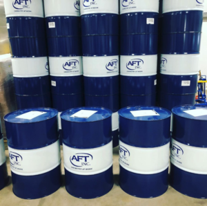 stacked up blue AFT Inc., barrels sitting on a concrete floor