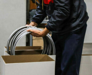 man loading saw blades into a tall white box